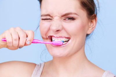 woman over-brushing her teeth